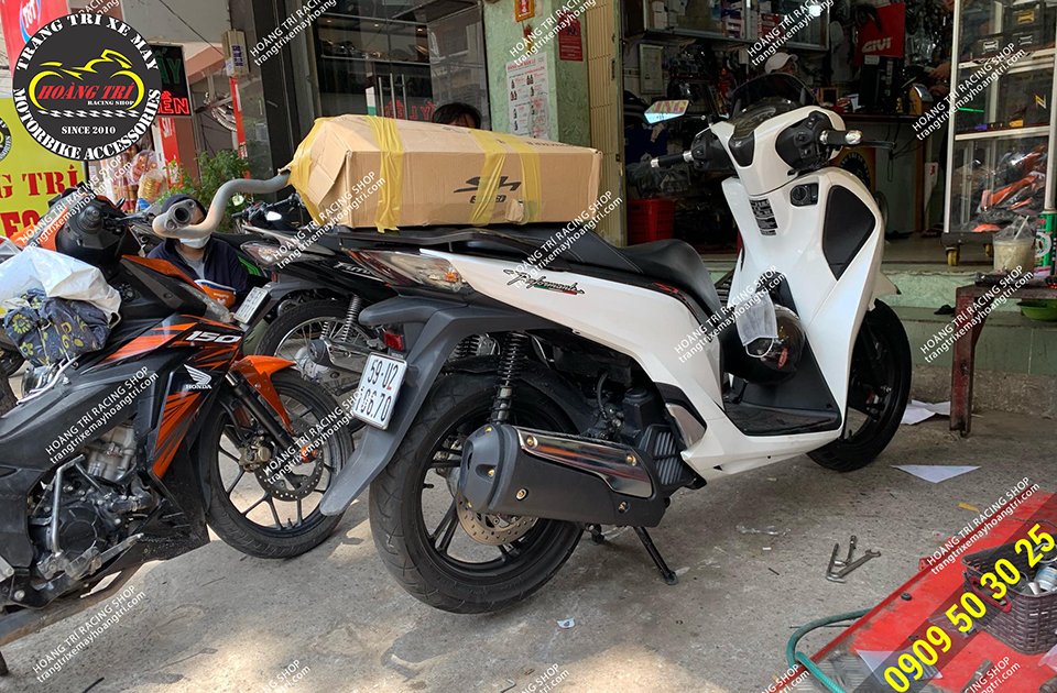 Trên yên xe chính là cây pô zin của xe được gói kỹ càng đưa khách mang về